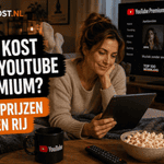 Sanne ligt languit op een bank in een gezellige woonkamer en kijkt naar een tablet. Op de achtergrond staat YouTube Premium op een televisie en links staat de titel ‘Wat kost een YouTube Premium?’ in de herkenbare Ditkost.nl-stijl.