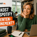 Persoon met een zwarte hoofdtelefoon zit aan een studietafel met laptop, notitieboek en studieboeken. Links staat de titel “Wat kost een Spotify Studentenabonnement?” in de Ditkost.nl-huisstijl en op de achtergrond is het Spotify-logo zichtbaar.